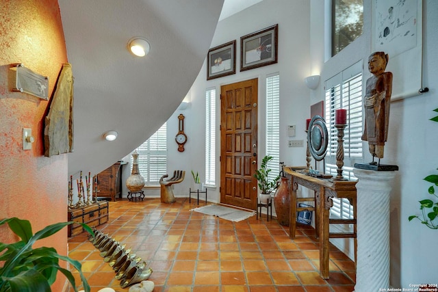 tiled foyer entrance featuring high vaulted ceiling and plenty of natural light