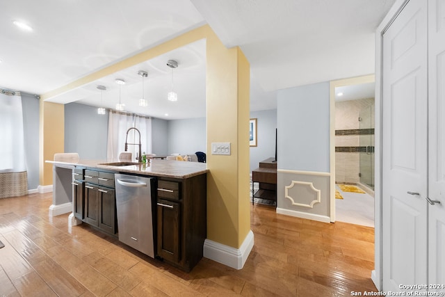 kitchen with sink, dark brown cabinets, hanging light fixtures, stainless steel dishwasher, and light hardwood / wood-style flooring