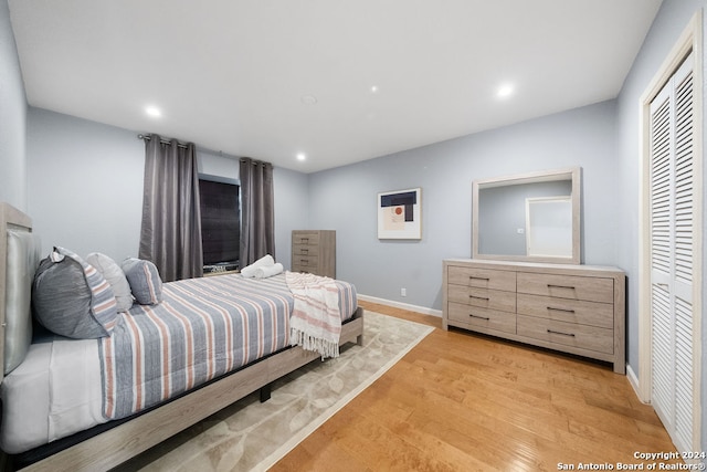 bedroom with light hardwood / wood-style floors and a closet