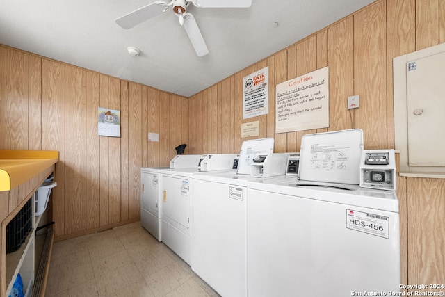 washroom featuring ceiling fan, wooden walls, and washing machine and clothes dryer