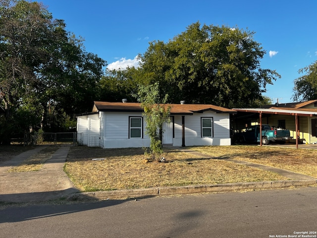 view of front of property featuring a front yard and a carport