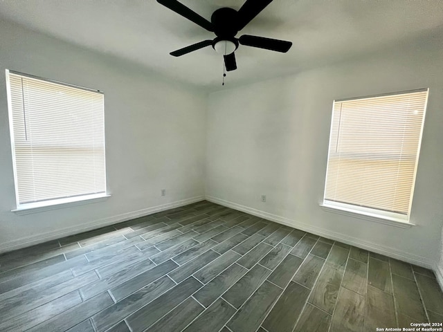 unfurnished room with ceiling fan and dark hardwood / wood-style flooring