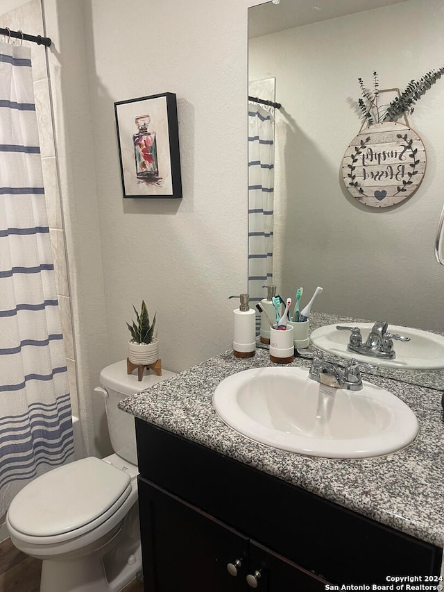 bathroom with vanity, toilet, and walk in shower