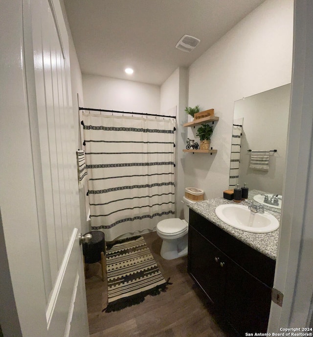 bathroom with vanity, hardwood / wood-style floors, toilet, and walk in shower