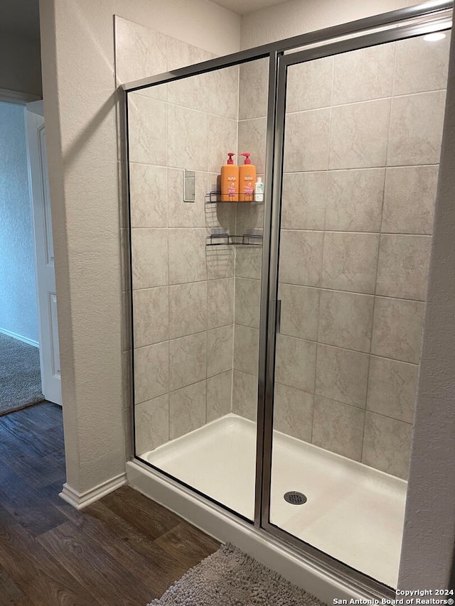 bathroom featuring wood-type flooring and an enclosed shower