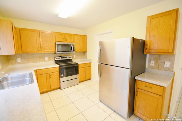 kitchen featuring light tile patterned floors, stainless steel appliances, tasteful backsplash, and sink