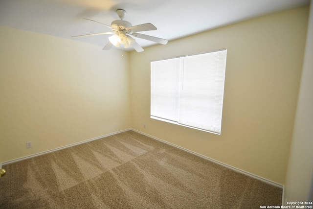 carpeted empty room featuring ceiling fan