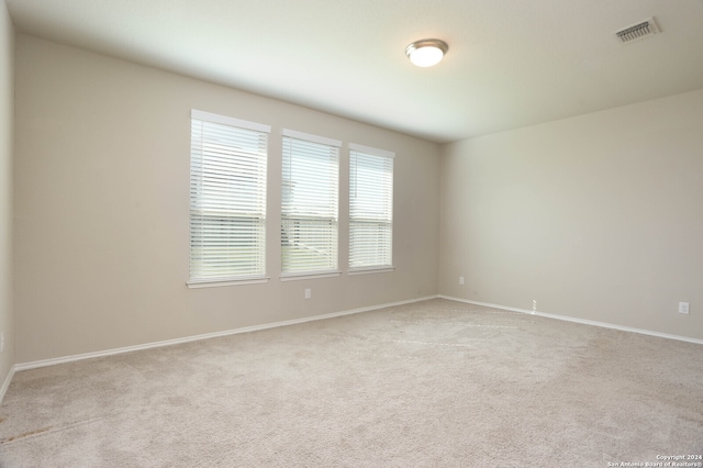 unfurnished room featuring light colored carpet