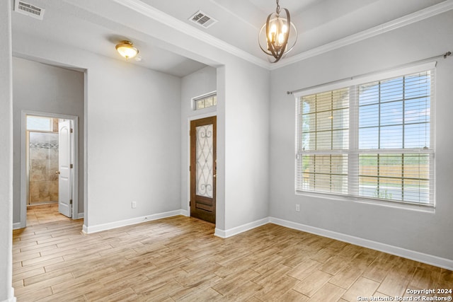 entryway featuring an inviting chandelier, crown molding, and light hardwood / wood-style floors