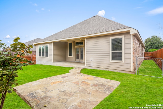 rear view of house with a patio and a lawn