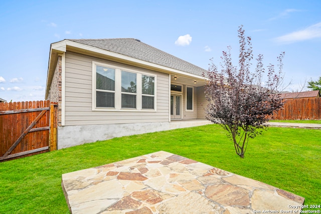 back of property featuring a yard and a patio area