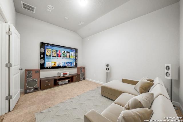 carpeted home theater room with vaulted ceiling