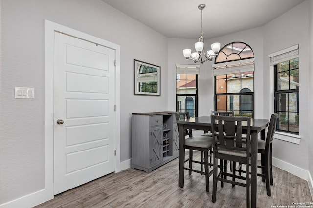 dining space with wood-type flooring and a chandelier