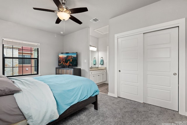 bedroom with a closet, ceiling fan, light carpet, and ensuite bathroom