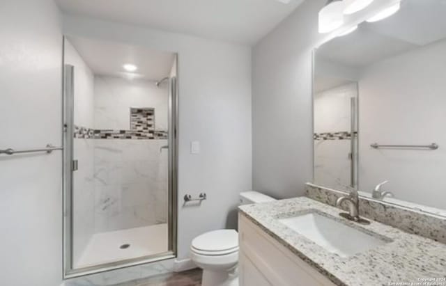 bathroom with vanity, toilet, and walk in shower