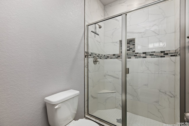 bathroom with toilet and a shower with shower door