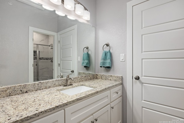 bathroom with vanity and a shower with shower door