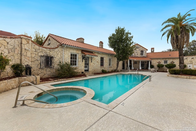 view of swimming pool featuring an in ground hot tub and a patio