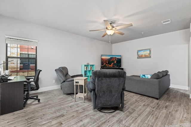 living room with a textured ceiling, wood-type flooring, and ceiling fan