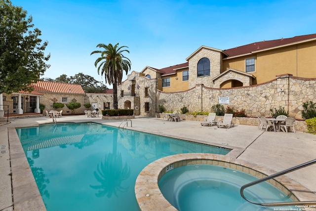 view of pool featuring a community hot tub and a patio