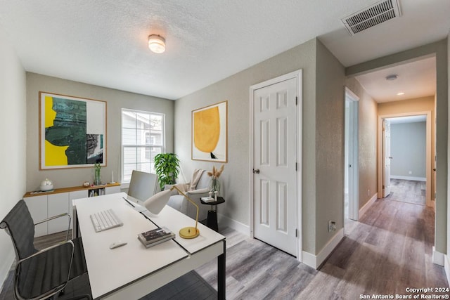 1703 Allende, San Antonio, TX 78237 - unfurnished bedroom with a textured ceiling, visible vents, wood finished floors, baseboards, and a closet