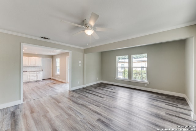 unfurnished living room featuring light hardwood / wood-style floors, ornamental molding, and ceiling fan