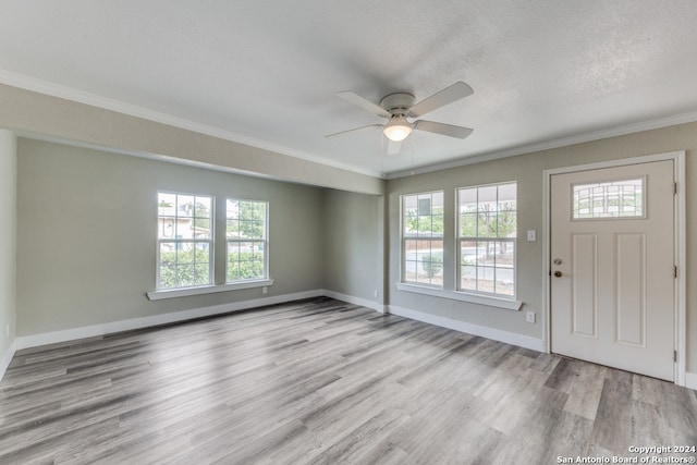 foyer featuring light hardwood / wood-style floors, ornamental molding, ceiling fan, and a wealth of natural light