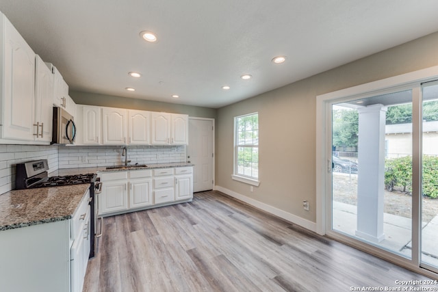 kitchen featuring white cabinetry, a healthy amount of sunlight, and range with gas stovetop