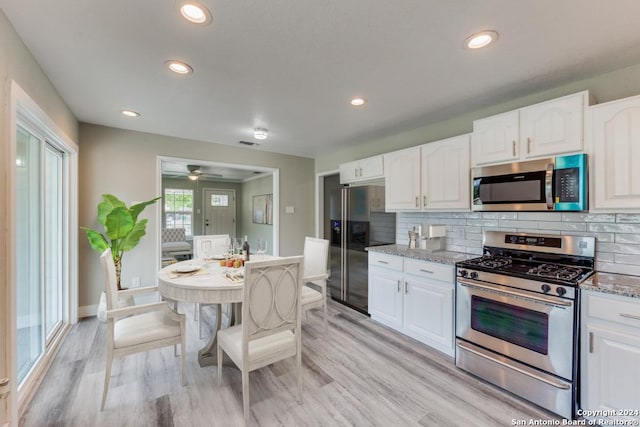 1703 Allende, San Antonio, TX 78237 - kitchen featuring decorative backsplash, white cabinets, light stone countertops, and stainless steel appliances