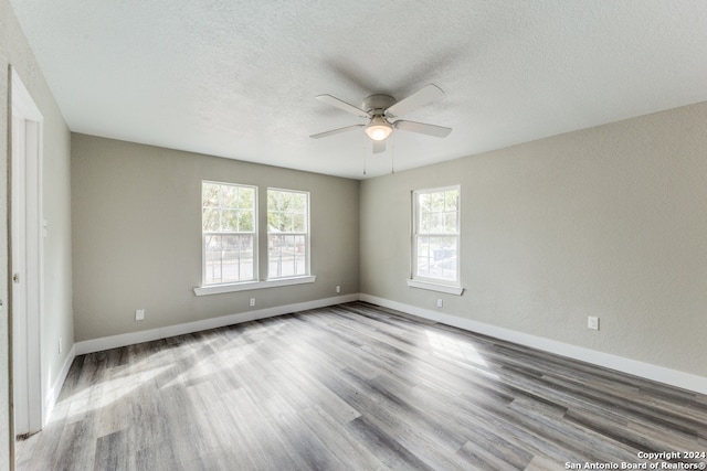 spare room featuring a textured ceiling, light wood-type flooring, and ceiling fan