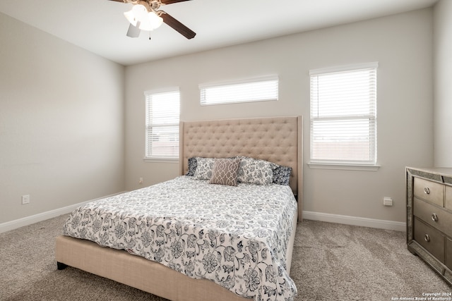 carpeted bedroom with multiple windows and ceiling fan