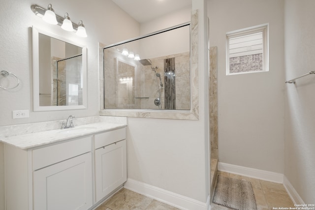 bathroom with vanity, tiled shower, and tile patterned flooring