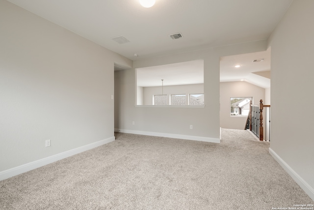 empty room with carpet flooring and lofted ceiling