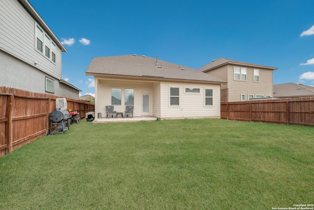 rear view of house with a yard and a patio area