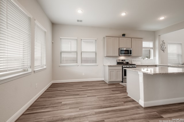 kitchen featuring light hardwood / wood-style floors, stainless steel appliances, and plenty of natural light