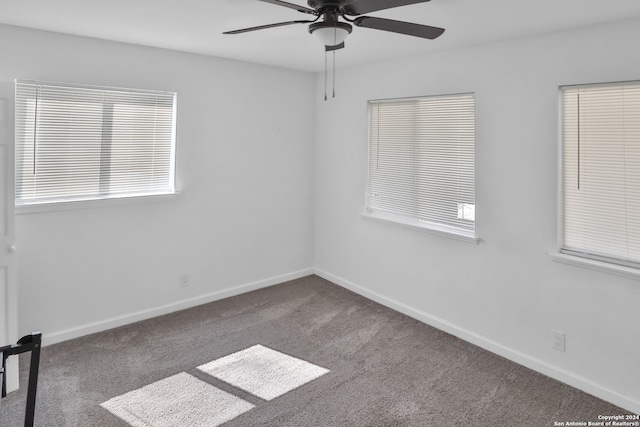 carpeted spare room with a healthy amount of sunlight and ceiling fan