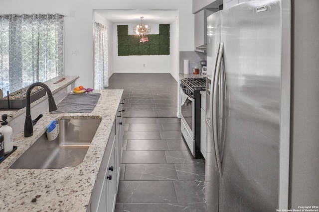 kitchen with sink, white cabinetry, hanging light fixtures, and stainless steel appliances