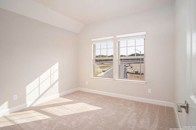 empty room with light carpet and vaulted ceiling