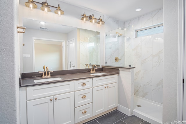 bathroom featuring vanity, a tile shower, and tile patterned flooring