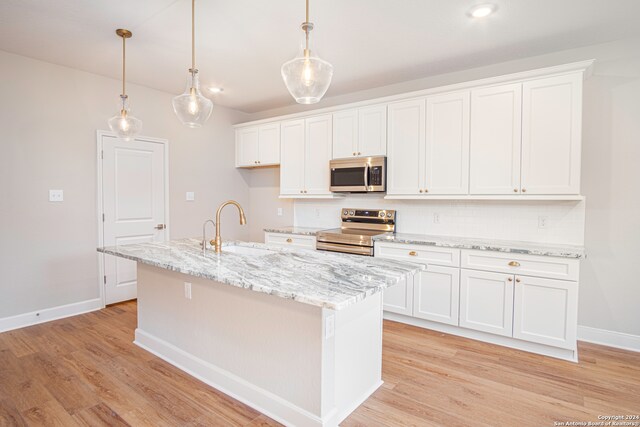 kitchen featuring a center island with sink, white cabinetry, and stainless steel appliances