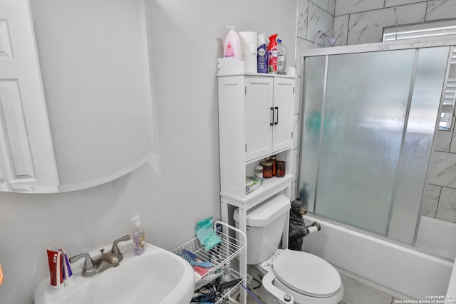 full bathroom with toilet, sink, and shower / bath combination with glass door