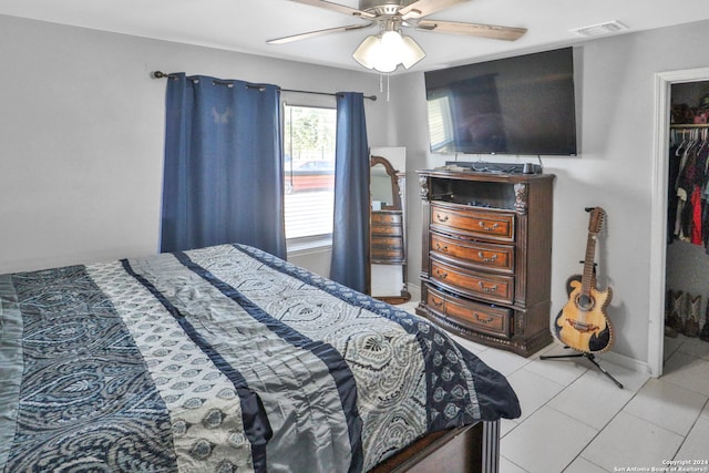 tiled bedroom with a spacious closet, a closet, and ceiling fan