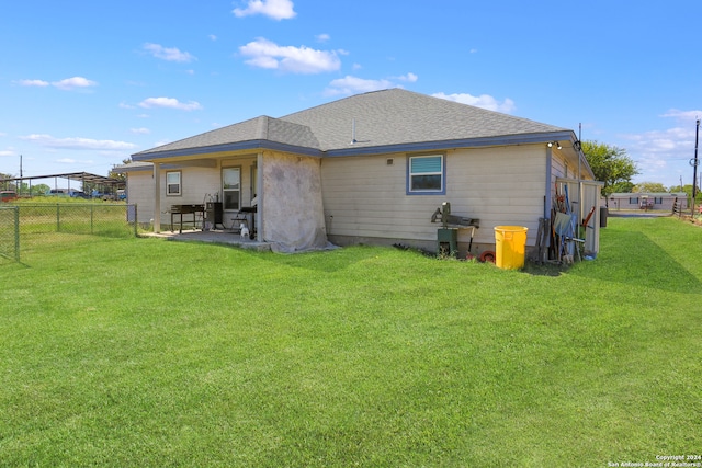 rear view of property with a patio and a lawn