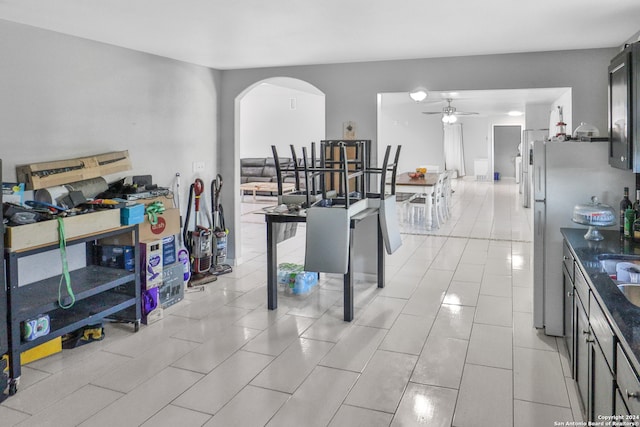 kitchen featuring stainless steel refrigerator, light tile patterned floors, and ceiling fan