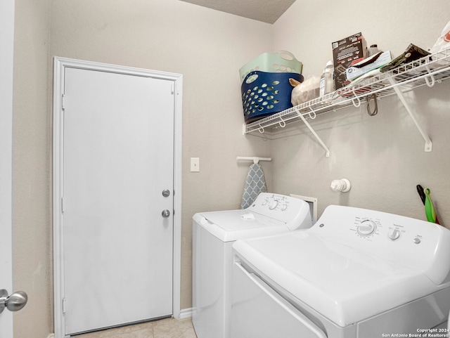 clothes washing area with independent washer and dryer and a textured ceiling