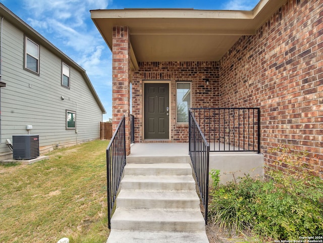 doorway to property featuring a yard and cooling unit