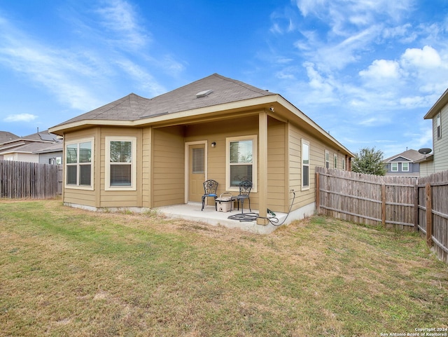 rear view of house with a patio area and a lawn