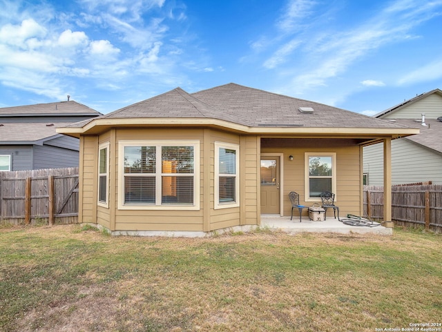 back of house with a patio and a lawn