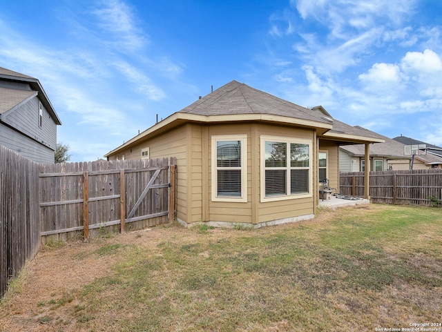 rear view of house featuring a yard and a patio