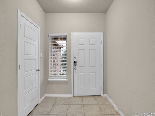 tiled entrance foyer with a textured ceiling